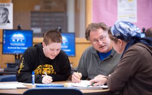 male teacher and two students at table